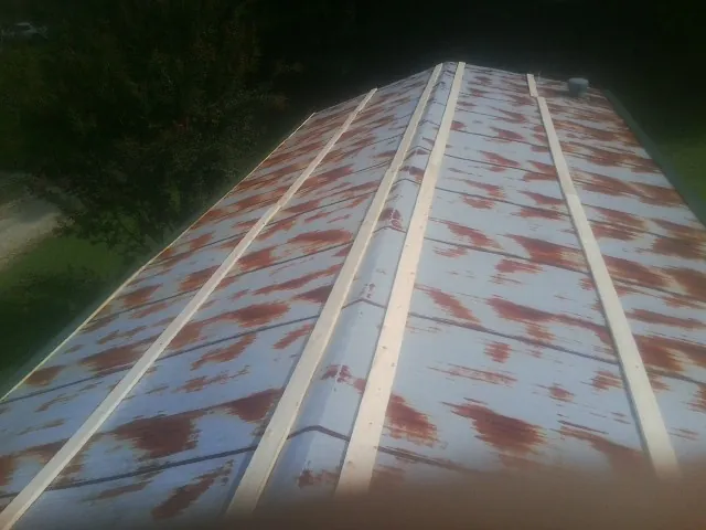 Rusted metal roof panels with new wood purlins before replacement — Storm Damage Roof Repair in Coal City by Roofing Brothers