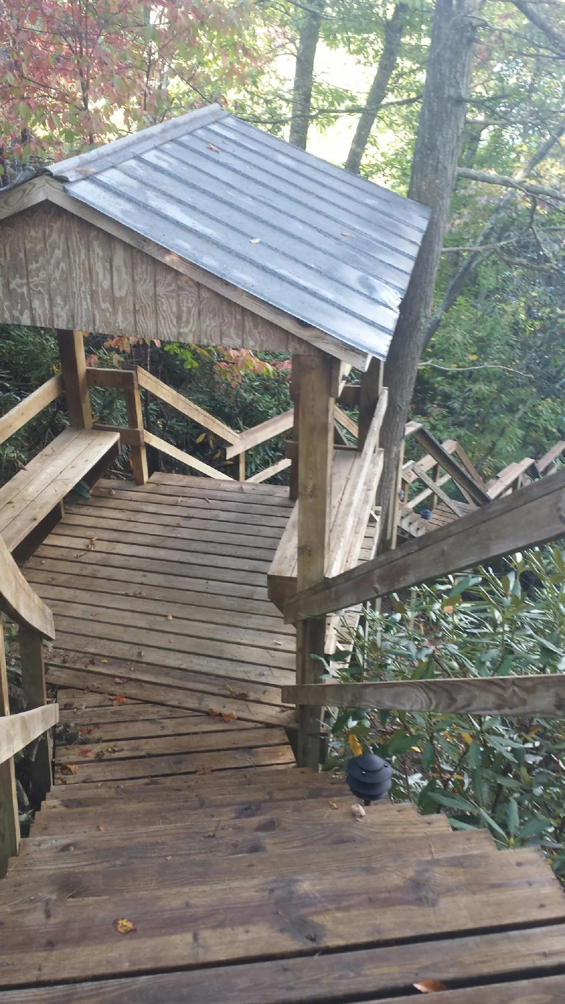 Metal roofed shelter over wooden steps on a wooded walkway — Skylight Repair & Installation work by our crew in Coal City