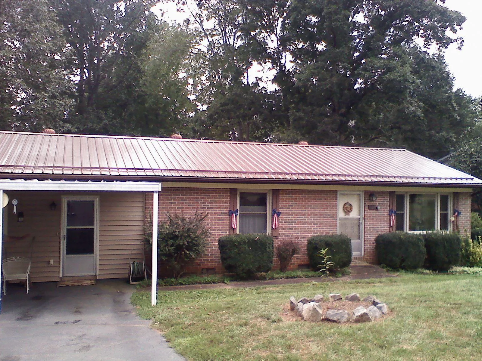 Bronze metal roof and carport on a brick ranch home — Roof Repair work by our crew in Coal City
